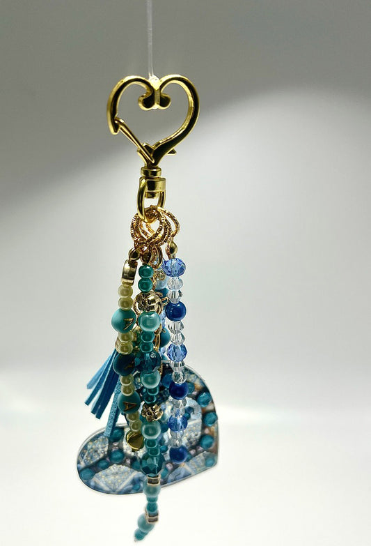 alt="Bijou de sac Vision O'Shiny Art & Lifestyle, motif sublimé œuvre originale, perles et strass posés à la main, série limitée numérotée" version attache en fome de coeur doré
